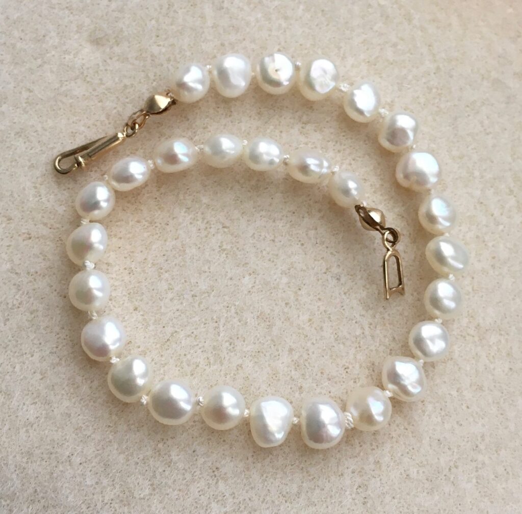I don't remember where I had gotten this bracelet but I did restring/knot it. These pearls are slightly off white. They are slightly flat on one side. This is a small bracelet. It measures 7-1/2" long, from end to end, including the clasp. So if your wrist is 7-1/2" this will not fit you. 